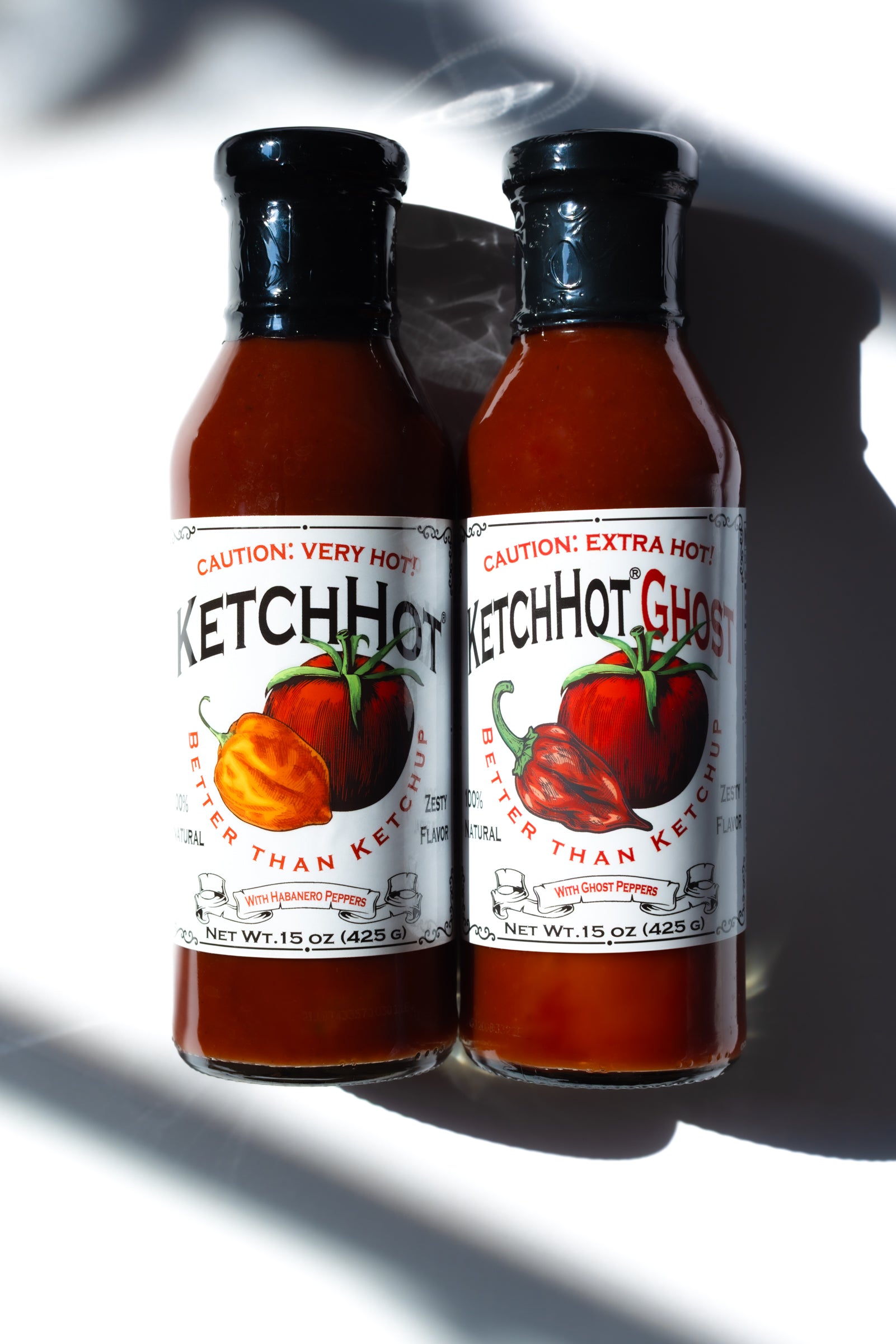 One each of a bottle of KetchHot and KetchHot Ghost on a white table